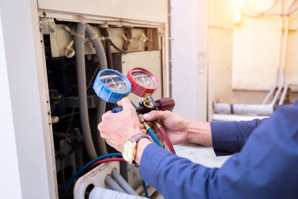 A heating and cooling technician uses a device to measure how efficiently a furnace is running.
